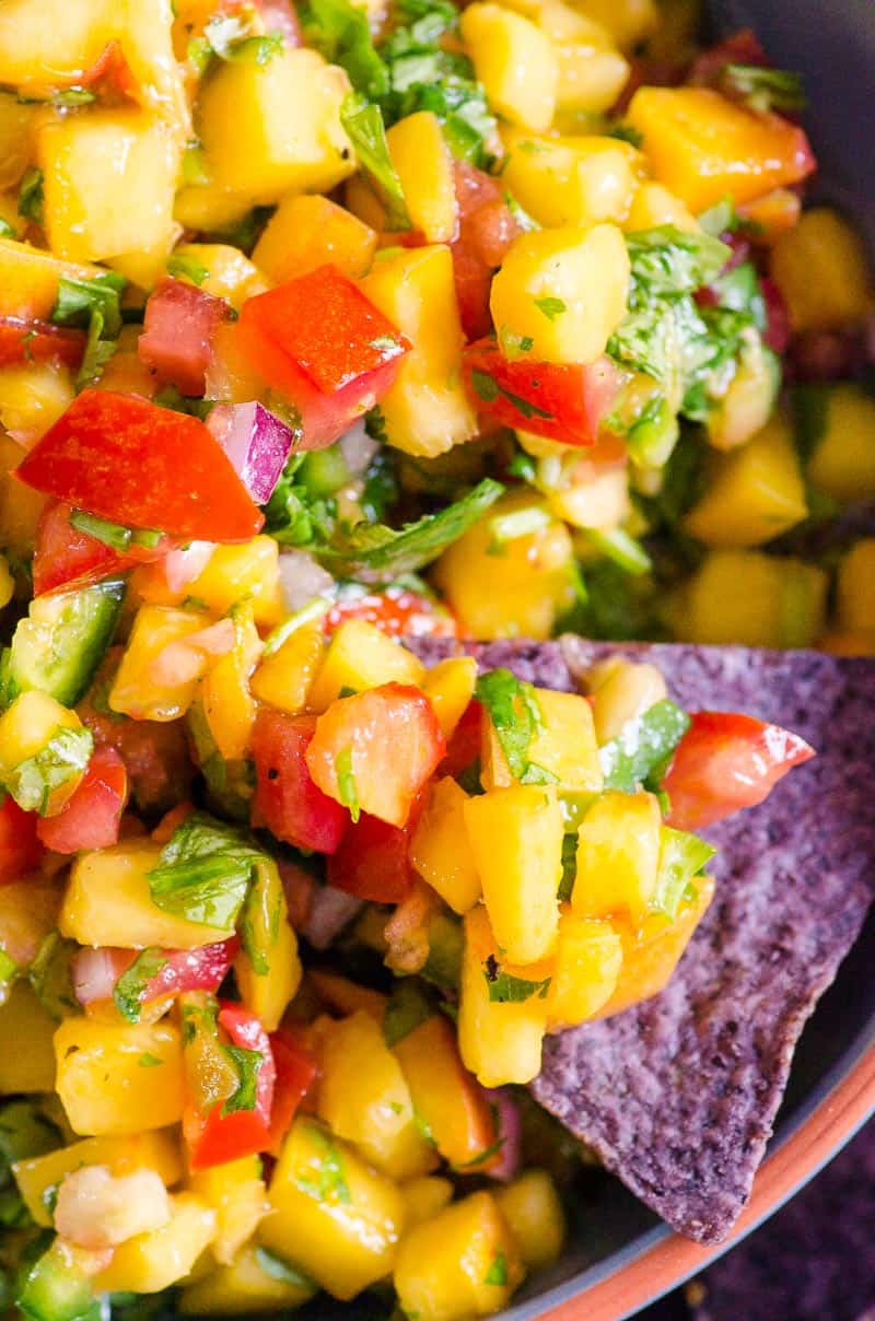 peach salsa scooped by a chip