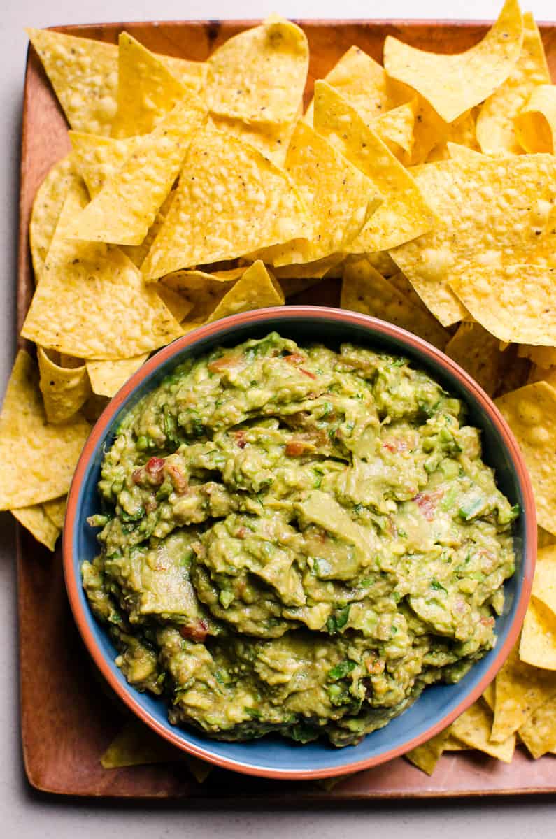 Guacamole salsa served on a platter with tortilla chips.