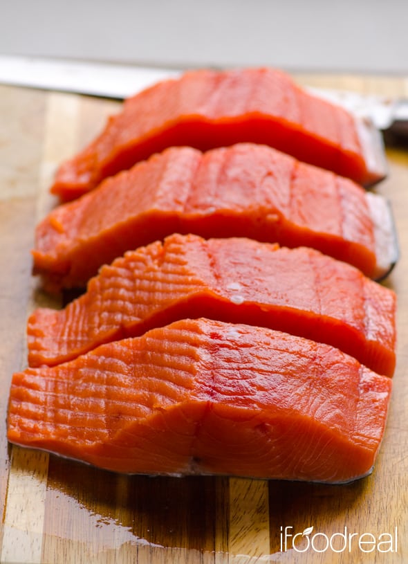 Sliced salmon fillet on a cutting board.