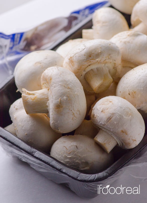 White mushrooms in a container.