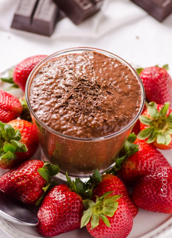 chocolate chia pudding in glass with fresh strawberries on plate