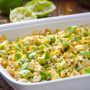 Cilantro lime cauliflower in a baking dish topped with avocado.