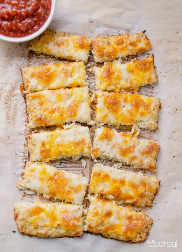 Cheesy Cauliflower Breadsticks cut on parchment paper