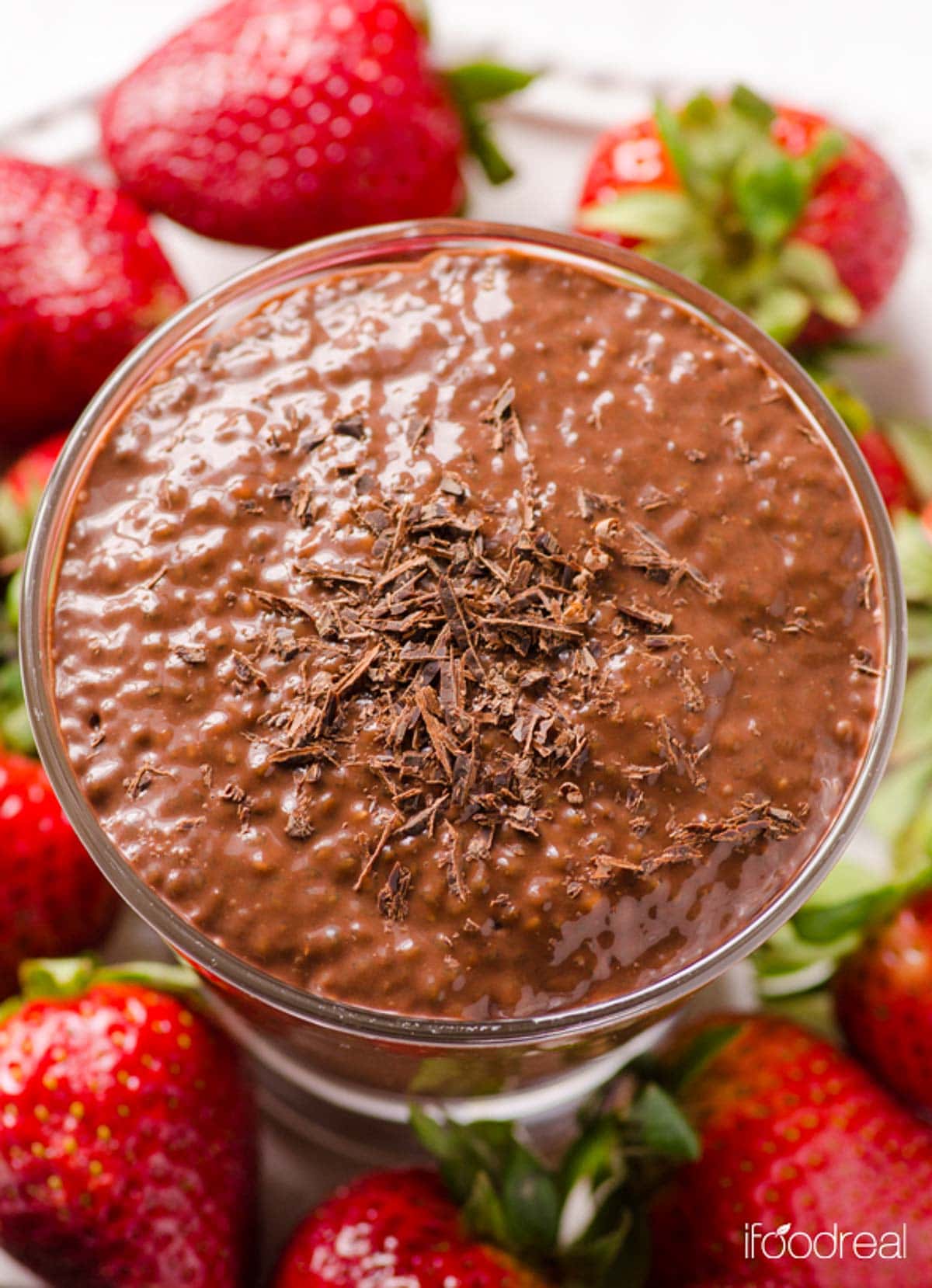 Looking down at chocolate chia pudding with chocolate shavings in a glass.