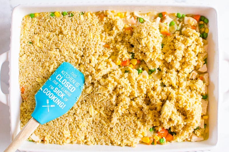 Placing topping on pot pie in casserole dish.