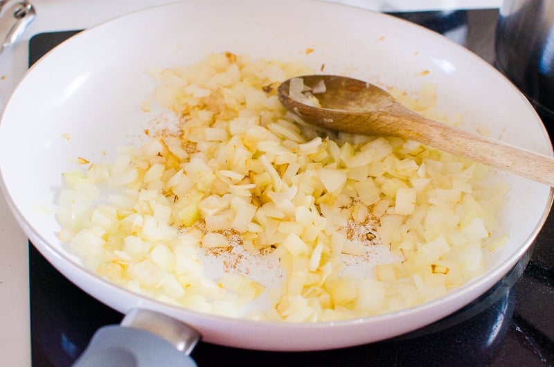 Sauteing onion in pan on stovetop.
