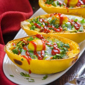 spaghetti squash halves filled with egg and drizzled with ketchup on serving plate