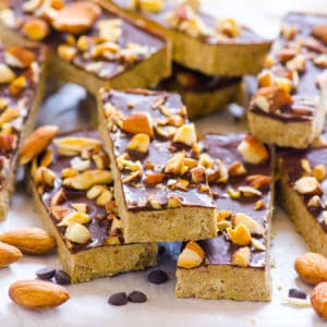 A stack of homemade protein bars with nuts on top.