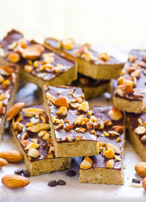 Homemade protein bars topped with chocolate and almonds and stacked on each other.