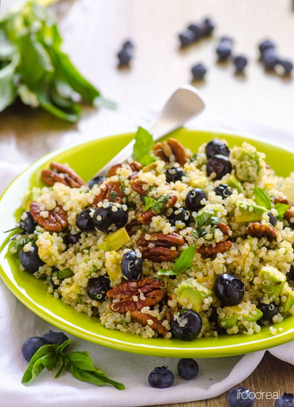 blueberry quinoa salad served in a green plate with a fork