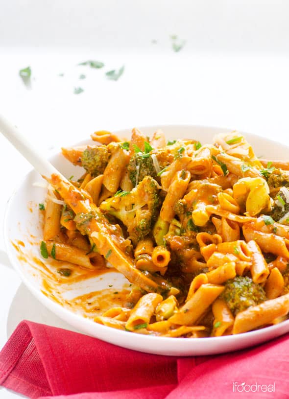 Broccoli and Penne Pasta Recipe in bowl with spoon on a red linen