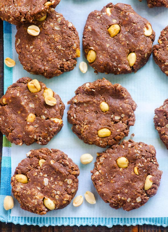 six no bake protein cookies on blue linen with peanuts