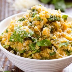 A bowl with pumpkin parmesan quinoa and spinach.