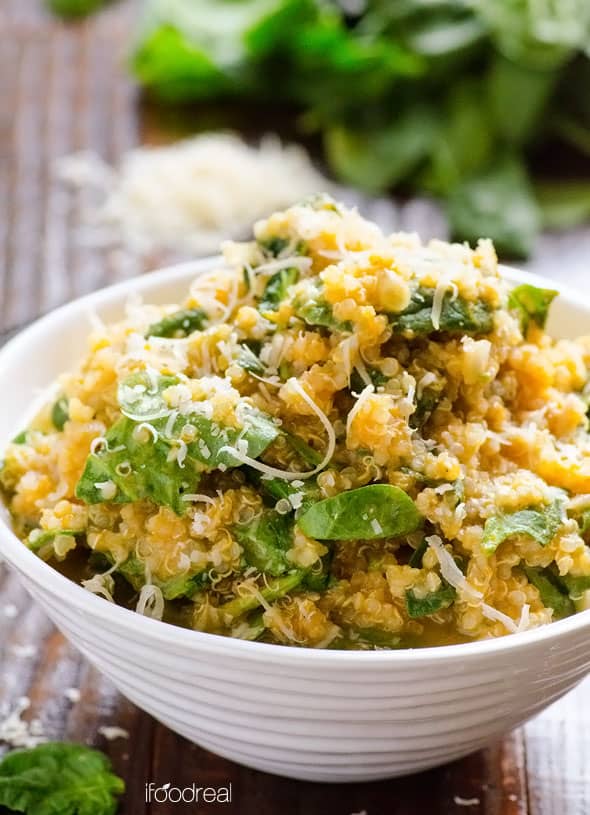 Parmesan pumpkin quinoa with spinach in white bowl on a counter.