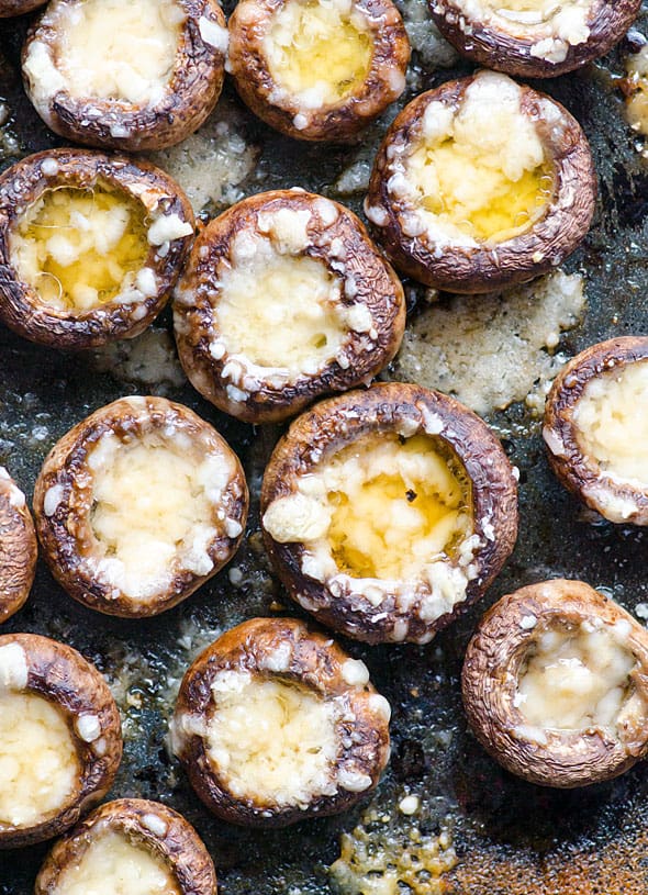 Parmesan mushrooms stuffed with parmesan on baking sheet.