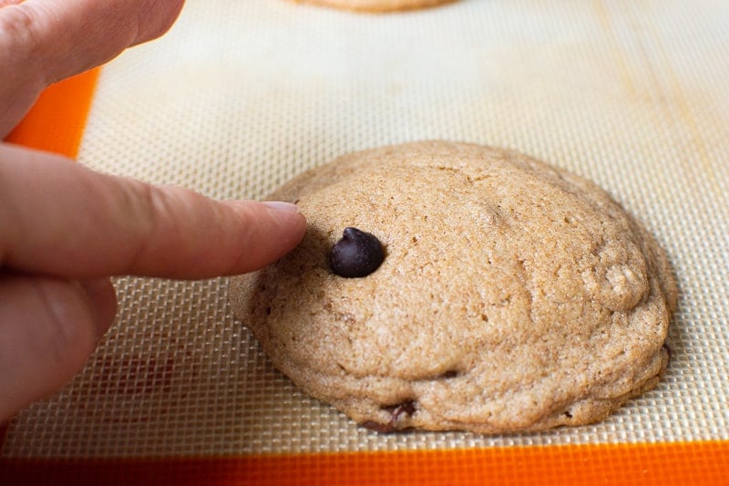 Inserting a chocolate chip into freshly baked cookie