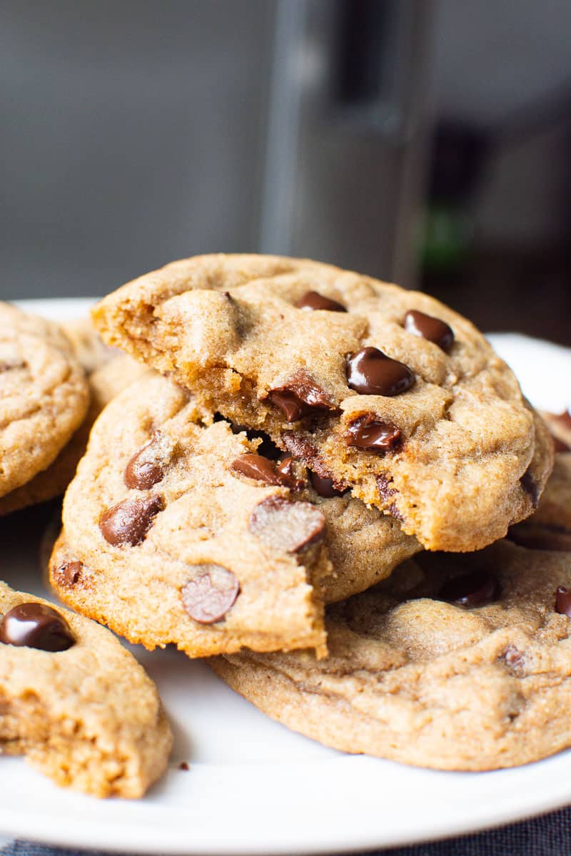 Healthy Chocolate Chip Cookies with one broken in half on a plate.