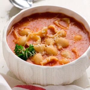 Alphagetti served in a bowl and garnished with parsley and parmesan cheese.