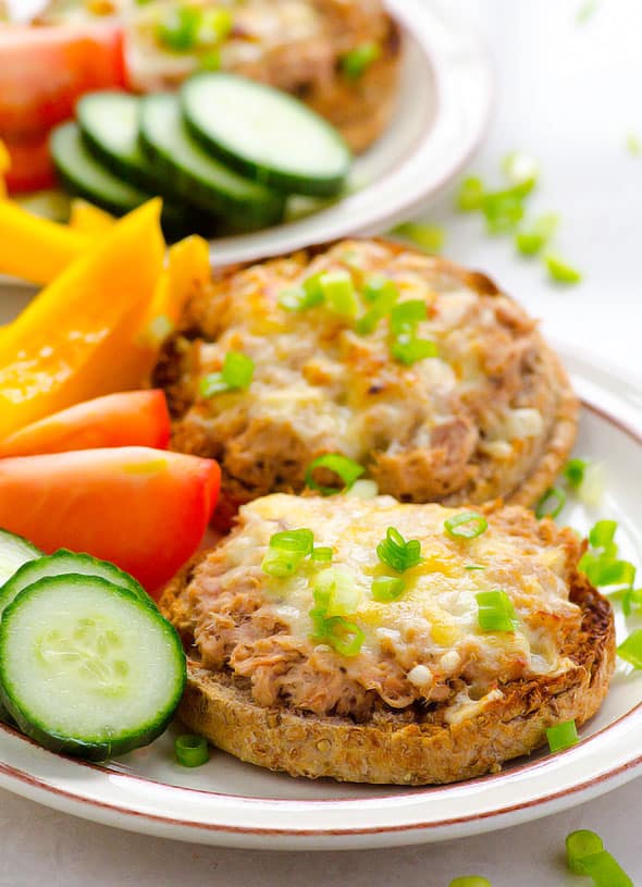 Healthy tuna melt garnished with green onions and served with vegetables on a plate.