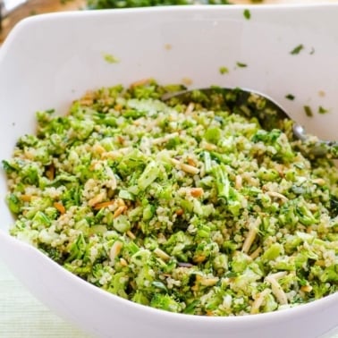 Broccoli quinoa salad with lemon dressing in white bowl.