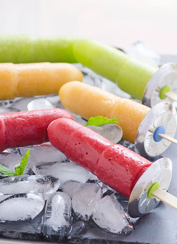 Healthy homemade popsicles on ice with mint leaves.