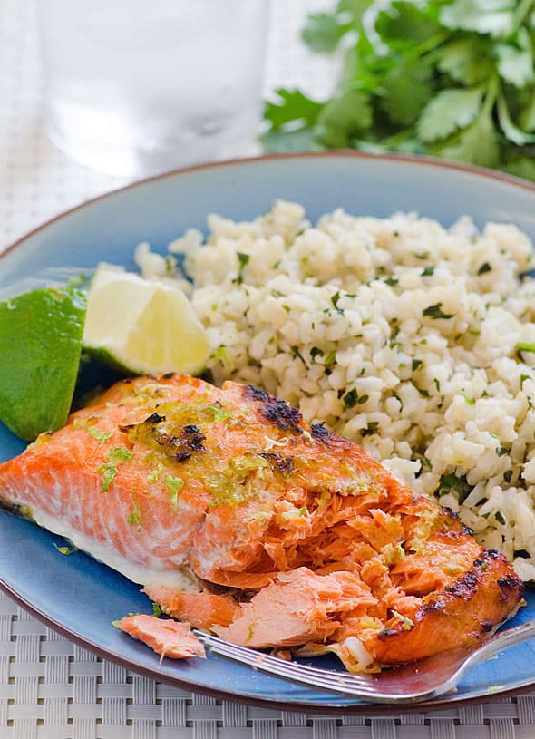 Lime ginger salmon with a side of rice on a blue plate.