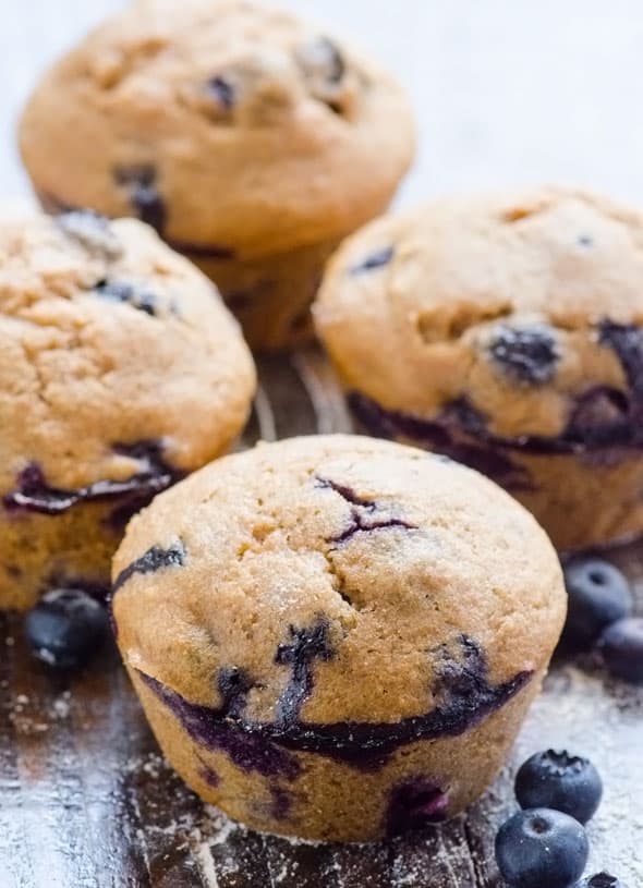 Healthy blueberry muffins on wood countertop.