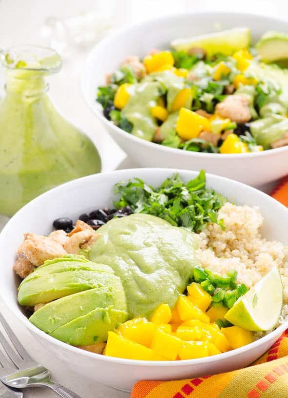 Two chicken quinoa bowls with mango, black beans and avocado dressing.