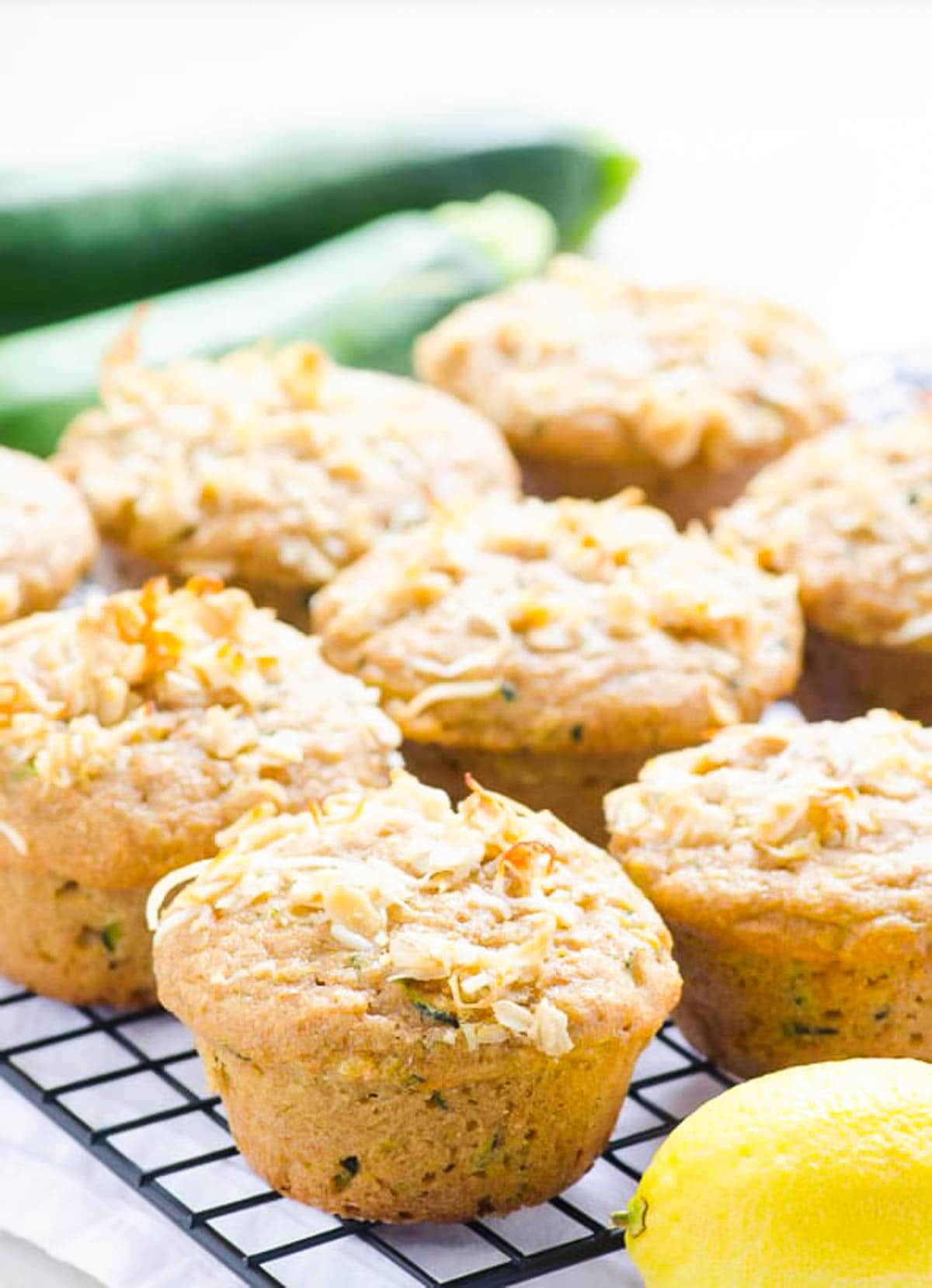 Healthy lemon zucchini muffins on a cooling rack with fresh lemon.