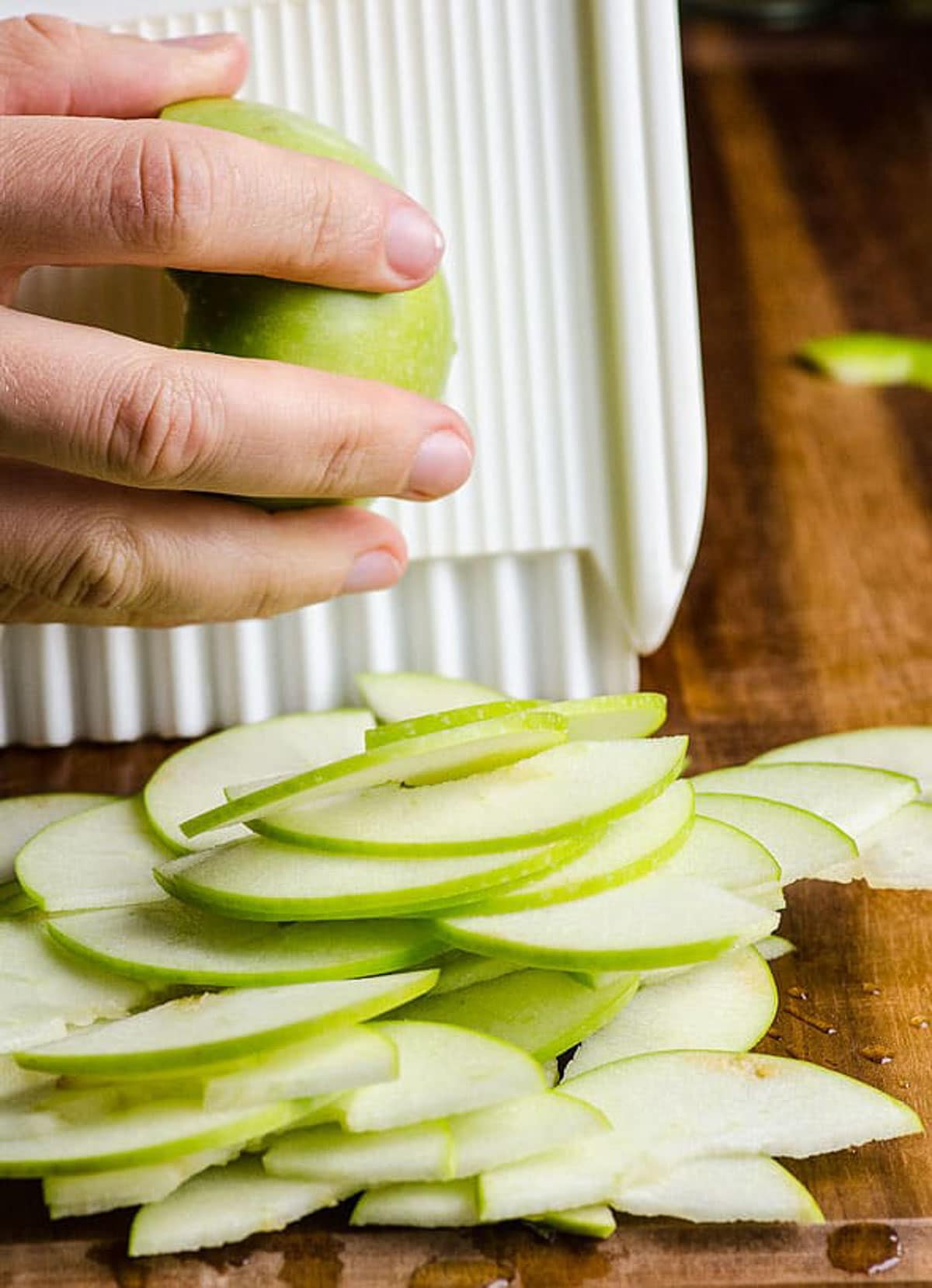 Slicing granny smith apples with mandoline.