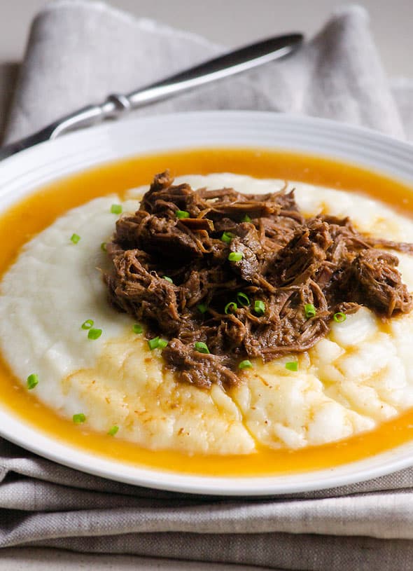 Plate of cauliflower mashed potatoes topped with Slow Cooker Balsamic Pot Roast