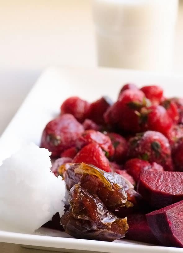 Plate of raw beets, strawberries, dates, apples and superfood coconut oil.