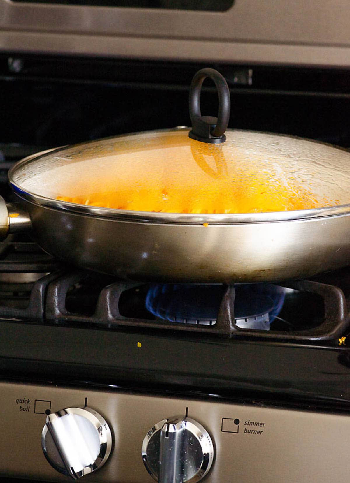 Butternut squash noodles in a skillet with lid on the stove.