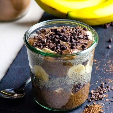 Chocolate banana chia pudding in glass jar with chocolate chips.