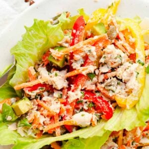 Canned salmon salad in lettuce cups on a plate.