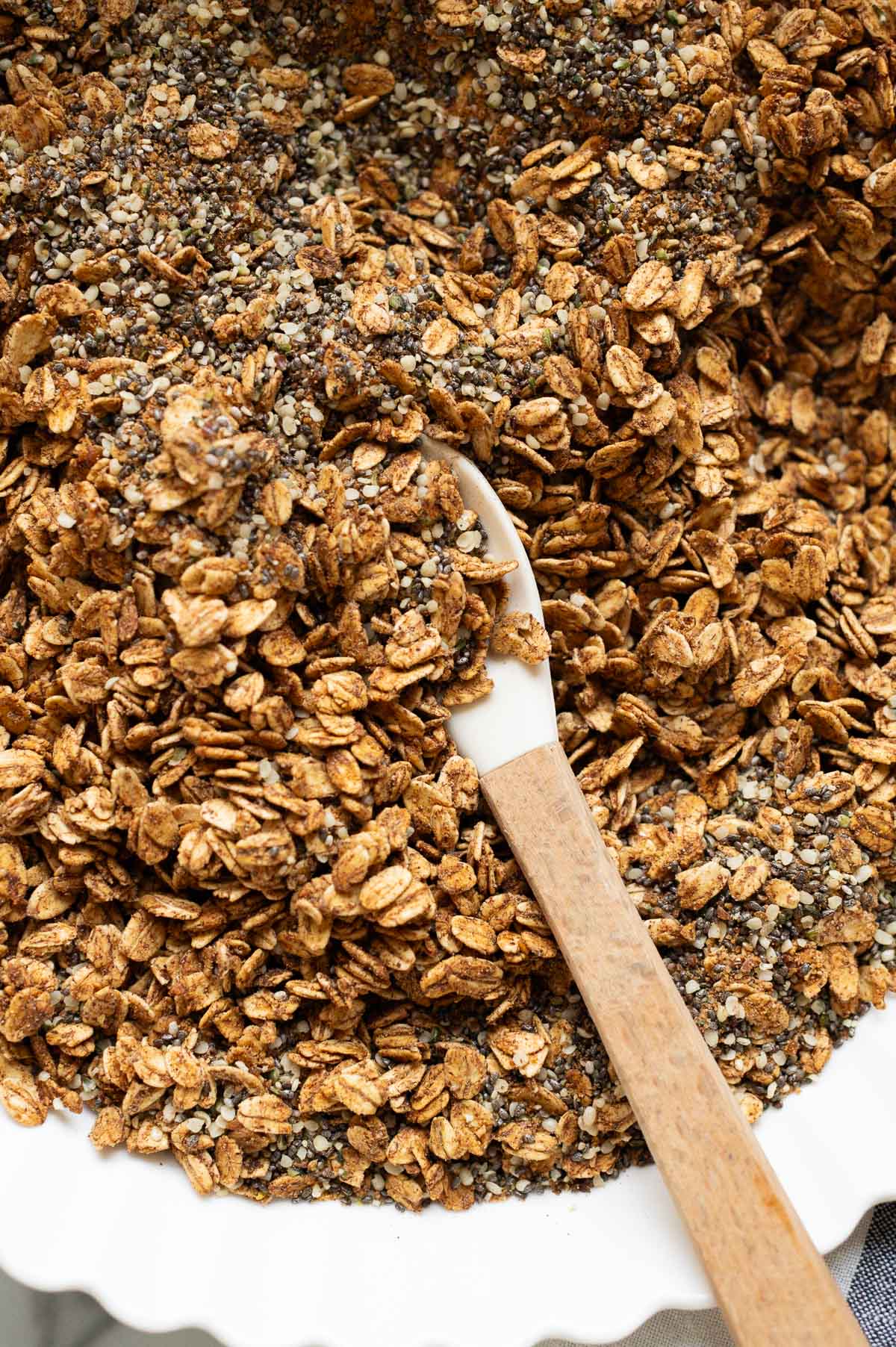 A closeup of homemade cereal with a spoon in a bowl.