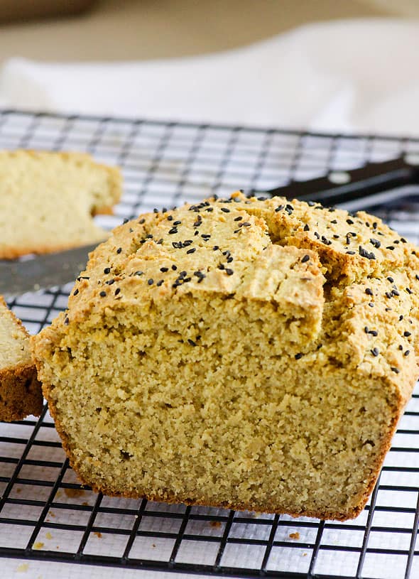 sliced quinoa bread on cooling rack with knife 