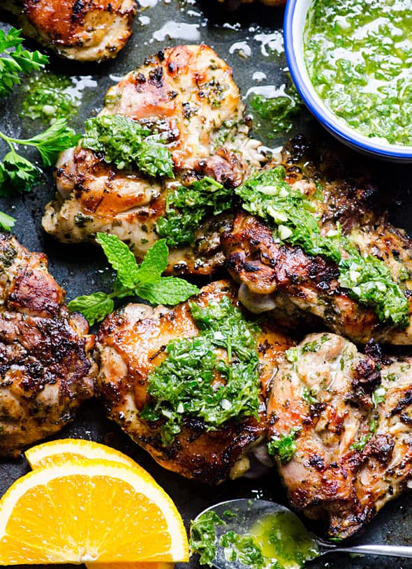 chimichurri chicken served with chimichurri sauce and garnished with orange