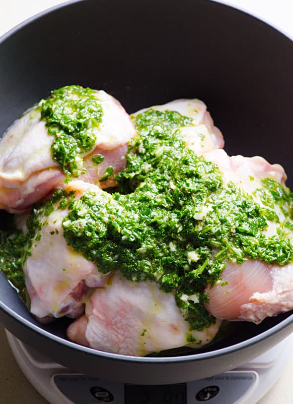 Chimichurri sauce placed over raw chicken. 