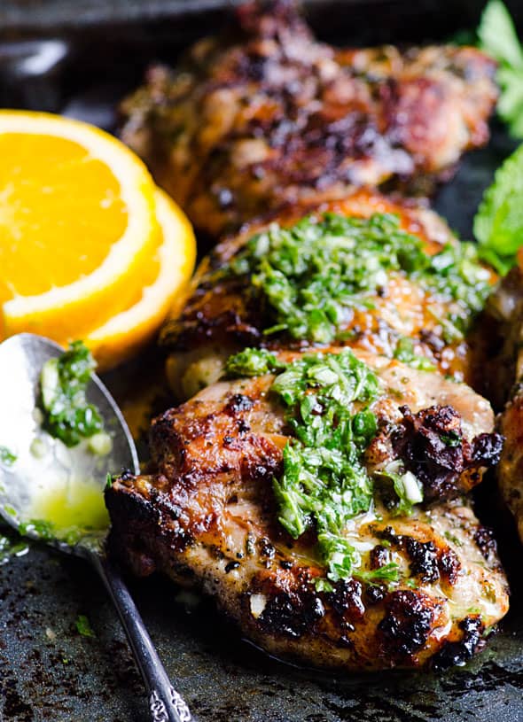 chimichurri chicken with sauce orange slices and spoon
