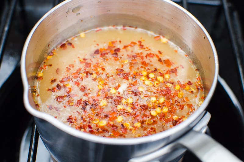 Maple syrup, rice vinegar, red pepper flakes, garlic and cornstarch in pot on stove. 