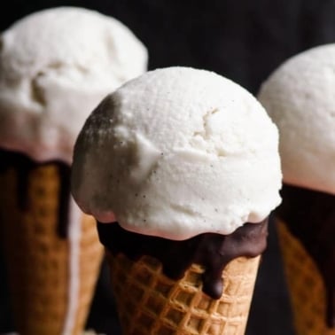 Vegan vanilla ice cream in chocolate dipped sugar cones.