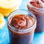 Hawaiian BBQ sauce in glass jars with pineapple slices on the counter.