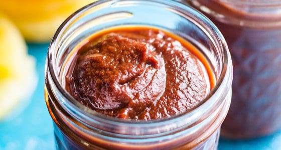 Hawaiian BBQ sauce in glass jars with pineapple slices on the counter.