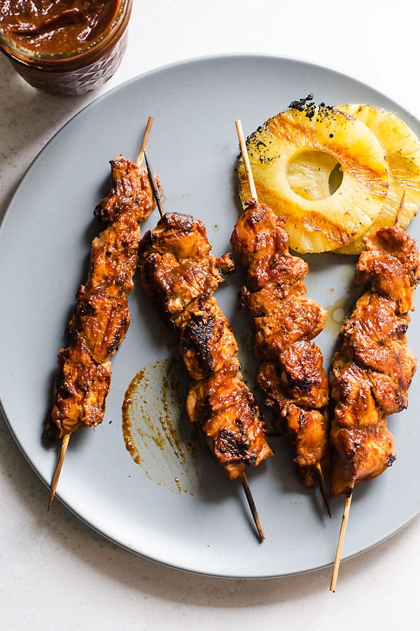 Chicken kabobs covered in Hawaiian BBQ Sauce served with grilled pineapple on a plate