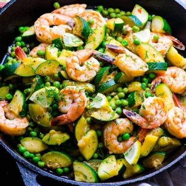 Shrimp, zucchini, peas, lemon and dill in cast iron skillet.
