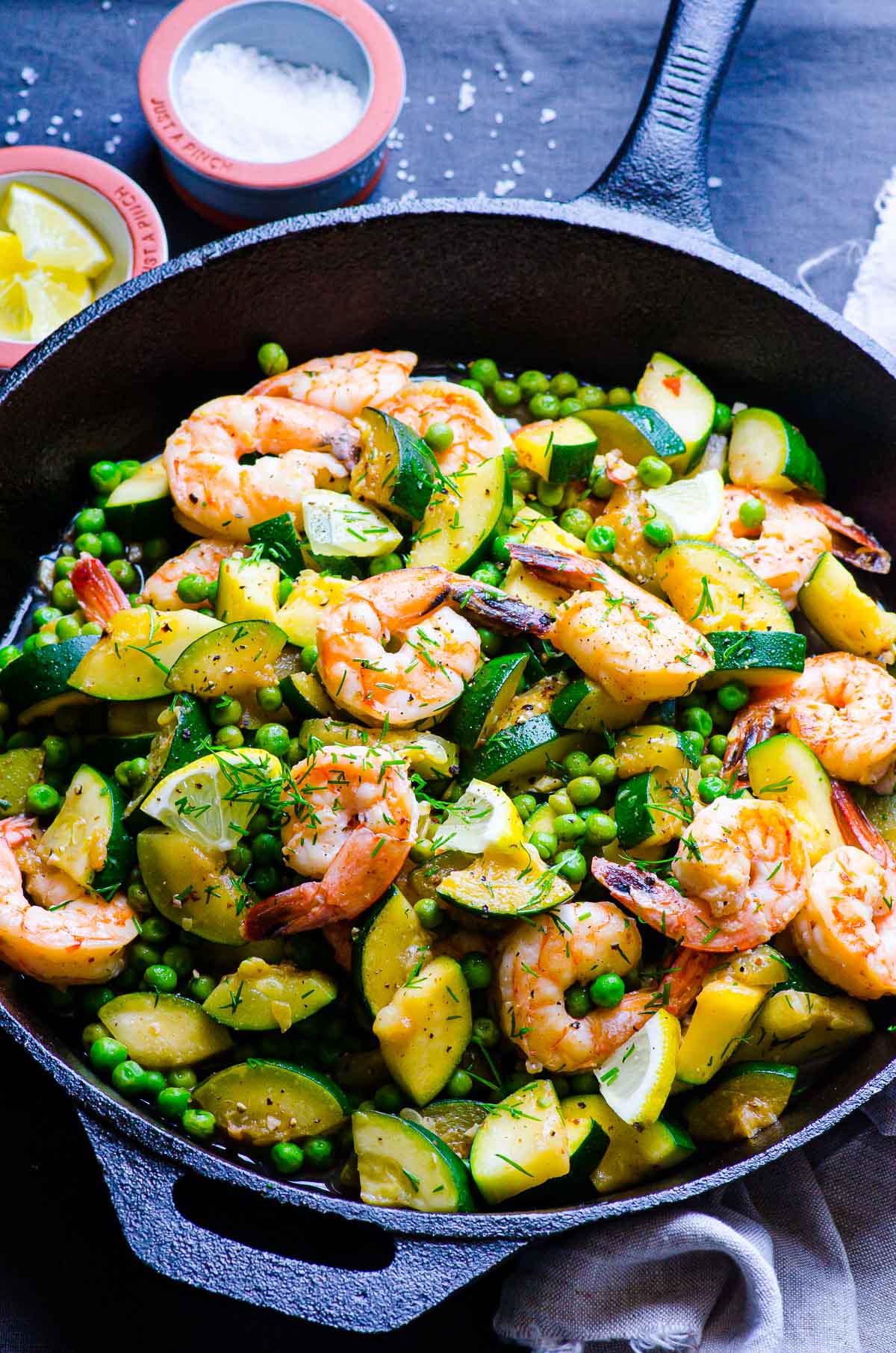 Shrimp, zucchini, peas, lemon and dill in cast iron skillet.