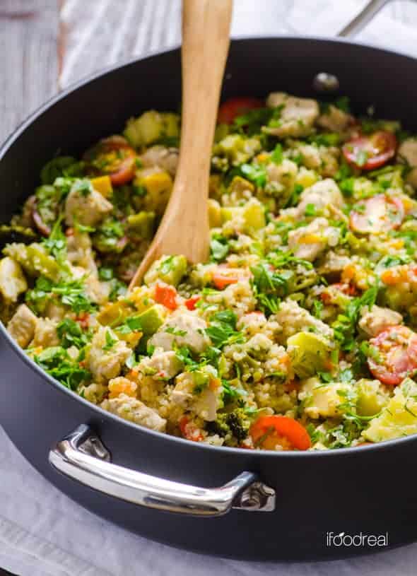 quinoa skillet with chicken and garden veggies in skillet with wooden spatula