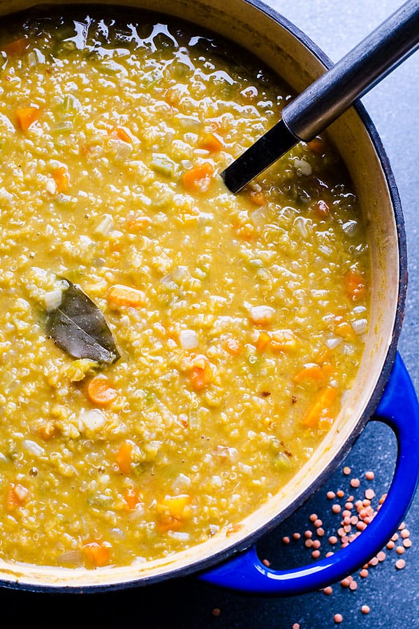 blue pot of red lentil soup with soup laddle