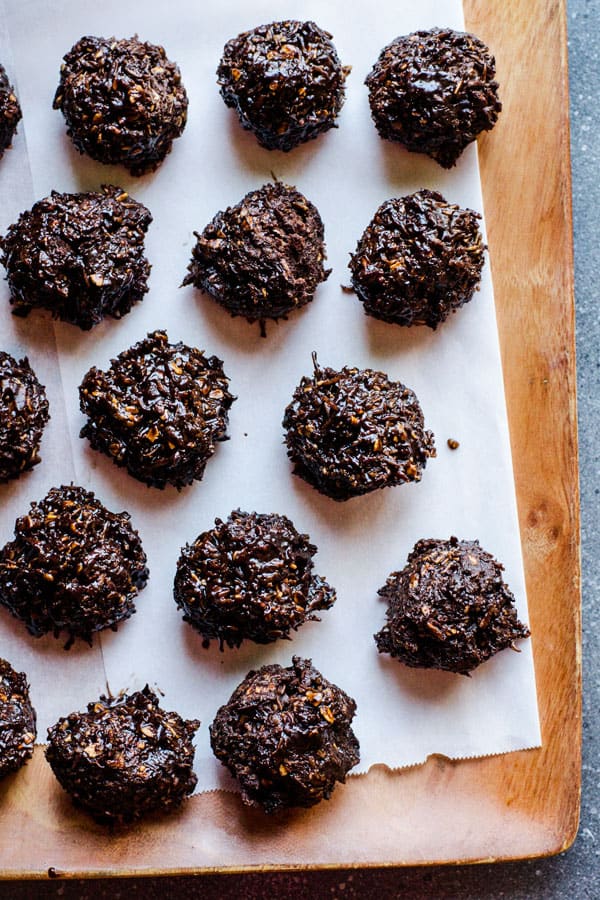 healthy chocolate snacks of coconut balls on a wooden platter lined with parchment
